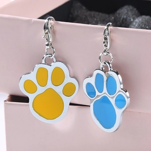 Paw shaped zinc alloy pet ID tags in blue and yellow enamel with lobster clasps