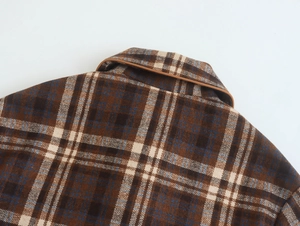 Close-up of vintage brown plaid wool jacket showing collar and shoulder texture details
