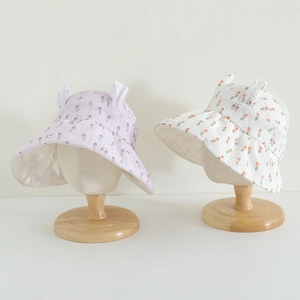 Detail of baby sun hats with cute rabbit ears and floral prints in purple and cream