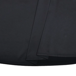 Close-up of the black dress hem showing the high-quality fabric texture and fine stitching