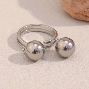 Detail of open ring featuring polished silver double spheres on a minimalist band