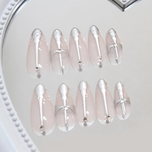 Almond press-on nails with 3D silver cross relief and metallic punk details on nude base