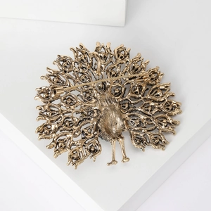 Retro golden peacock brooch with cutout design and vintage finish on white background