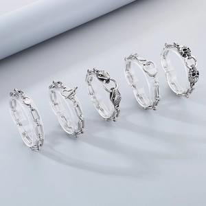 Close-up of five punk-style stainless steel rings with skull and snake motifs