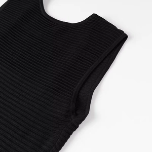 Detail of the high-quality black ribbed knit texture and sleeve stitching on the dress