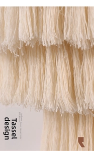 Macro shot of tiered cream cotton tassels showing soft texture and bohemian fringe detail