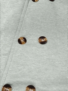 Detail of light green blend fabric texture and brown amber-patterned button on coat