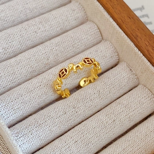 Macro shot of gold-plated adjustable ring with cat and coin reliefs in a jewelry box