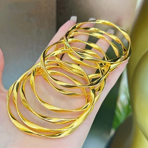 Polished 18k gold plated Mobius twisted cuff bracelets in a stack for women