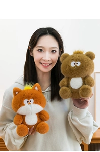 Detailed view of soft brown bear and orange fox plush toys held in hands