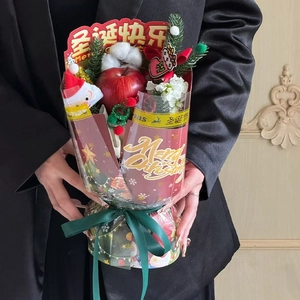 Chic Christmas bouquet with red apple and cotton held by a model in a black suit