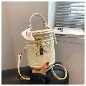 Detail of cream barrel bucket bag with embossed texture and silk scarf handle