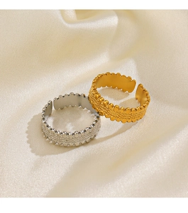 Macro detail of adjustable open rings with beaded texture in gold and silver finish