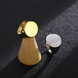 Minimalist oval signet rings in gold and silver steel on wooden display stands