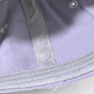Detailed close-up of light purple baseball cap interior stitching and grey reinforced tape