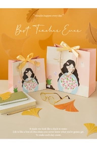 Close-up of pink teacher gift bags with cartoon illustrations and yellow silk bows