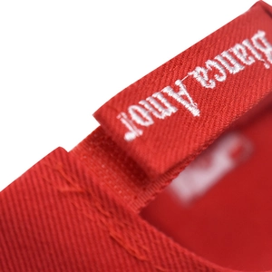 Close-up of Bianca Amor embroidery on red twill cotton baseball cap back strap