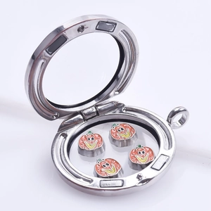 Detailed view of silver floating charm locket with orange enamel pumpkin charms inside