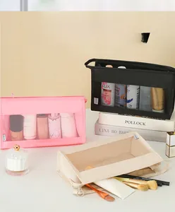 Three travel toiletry bags in pink, black, and beige with transparent mesh design and top handle