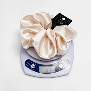Detailed scale view of 18cm pink satin oversized scrunchie weighing 27.7g with handmade tag