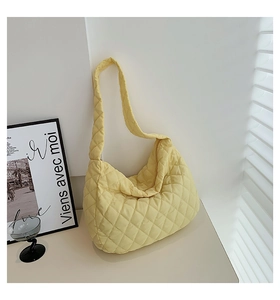 Detailed view of yellow quilted tote bag with soft padded texture and stylish cloud shape