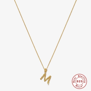 Detailed macro view of gold plated S925 sterling silver M letter pendant with diamond accents