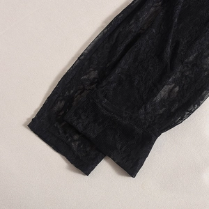 Détail de manchette en dentelle noire florale avec texture résille et broderie pure