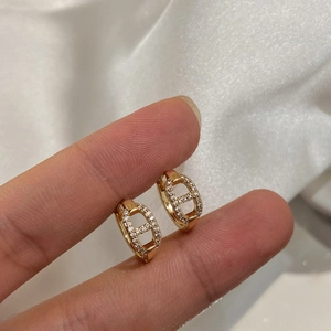 Macro shot of gold-plated pig nose earrings with micro-set zircon on white silk background