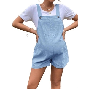 Detail of adjustable maternity denim overalls in light blue with functional side pockets
