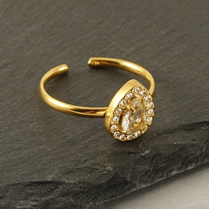 Adjustable 18k gold plated teardrop ring with sparkling zircon on a dark textured surface