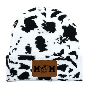 Black and white cow print knit beanie hat with MOM leather patch on the folded brim