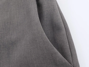 Détail de la couture de la poche latérale et texture du tissu gris foncé du blazer