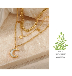 Detailed view of triple-layered gold stainless steel necklace with star and moon charms