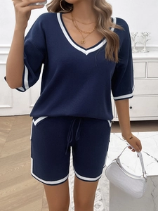 Detailed knit texture of the dark blue v-neck top with white stripe accents