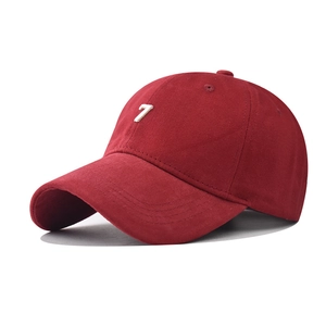 Detail of red cotton baseball cap featuring white 3D letter 7 embroidery and curved brim