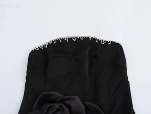 Dettaglio dell'abito in raso nero con frange di strass argentati scintillanti