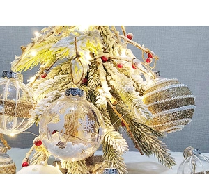 Close-up of 8cm handmade Christmas ornaments with jute rope and pearls on snowy tree branches