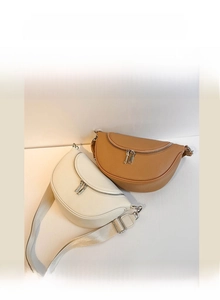 Close-up of crescent shoulder bags in beige and camel showing pebbled leather texture