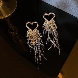 Detail view of heart-shaped drop earrings with silver tassels and sparkling rhinestones
