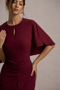 Dettaglio abito bordeaux con scollo cut-out ed eleganti increspature sulla vita alta