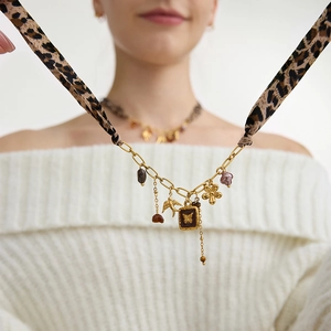 Collier bohème avec ruban léopard et breloques vintage porté par un mannequin