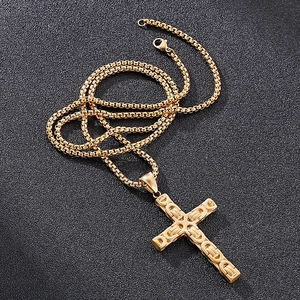 Vue détaillée d'un pendentif croix dorée avec texture byzantine sur une chaîne vénitienne
