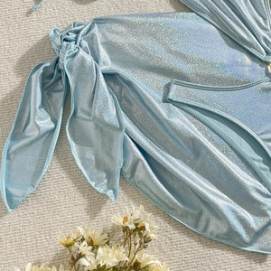 Gros plan du tissu bikini à paillettes bleu clair avec nœud décoratif et texture scintillante
