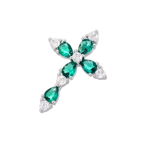 Macro detail of silver cross pendant featuring a pear-cut green gemstone and clear crystals