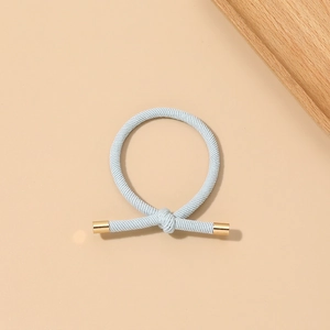 Detailed view of light blue elastic hair tie featuring a knot and gold metal fastener