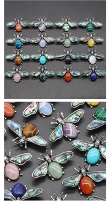 Detailed macro view of crystal and abalone shell bee brooches with colorful gemstones
