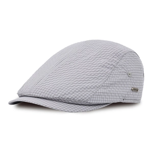 Macro shot of grey plaid seersucker newsboy cap showing metallic logo and fabric texture