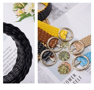 Detail of woven leather belts with gold round buckles in multiple fashion colors