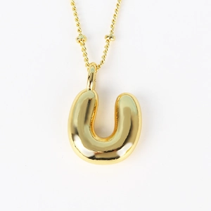 Close-up of polished gold 3D balloon initial U pendant with fine link chain necklace