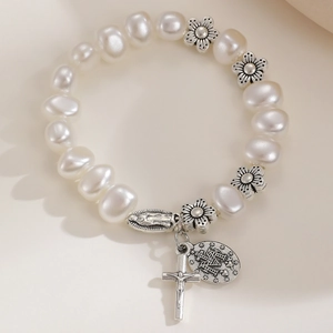 Macro view of vintage beaded bracelet featuring religious icons and silver cross charms